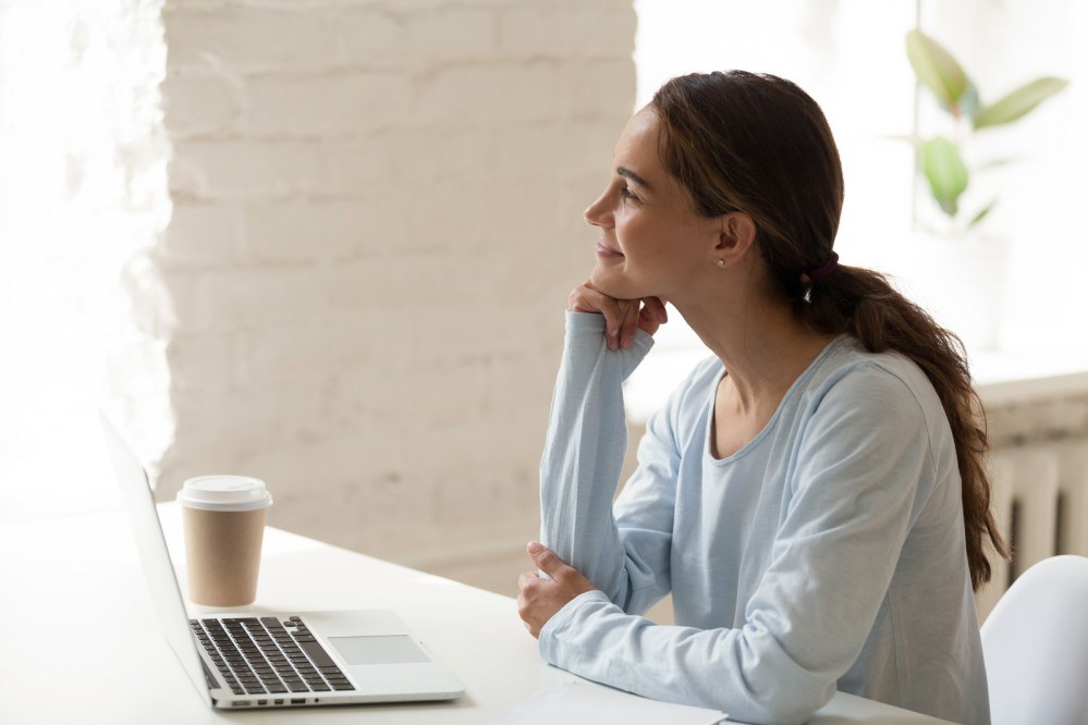 Photo of woman working from home, smiling to herself