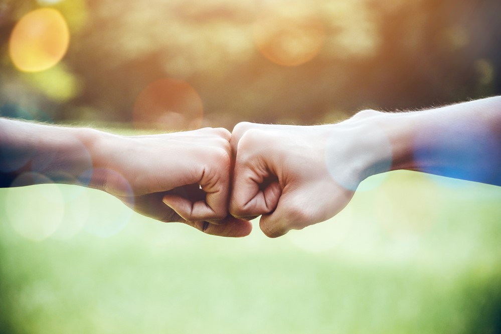 Image of two people bumping fists