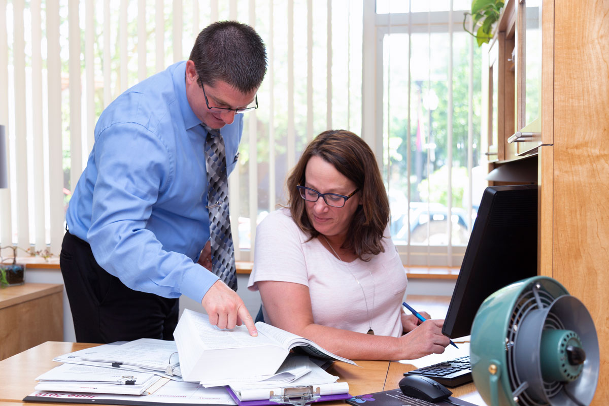 Photo of two people in an office looking at a document