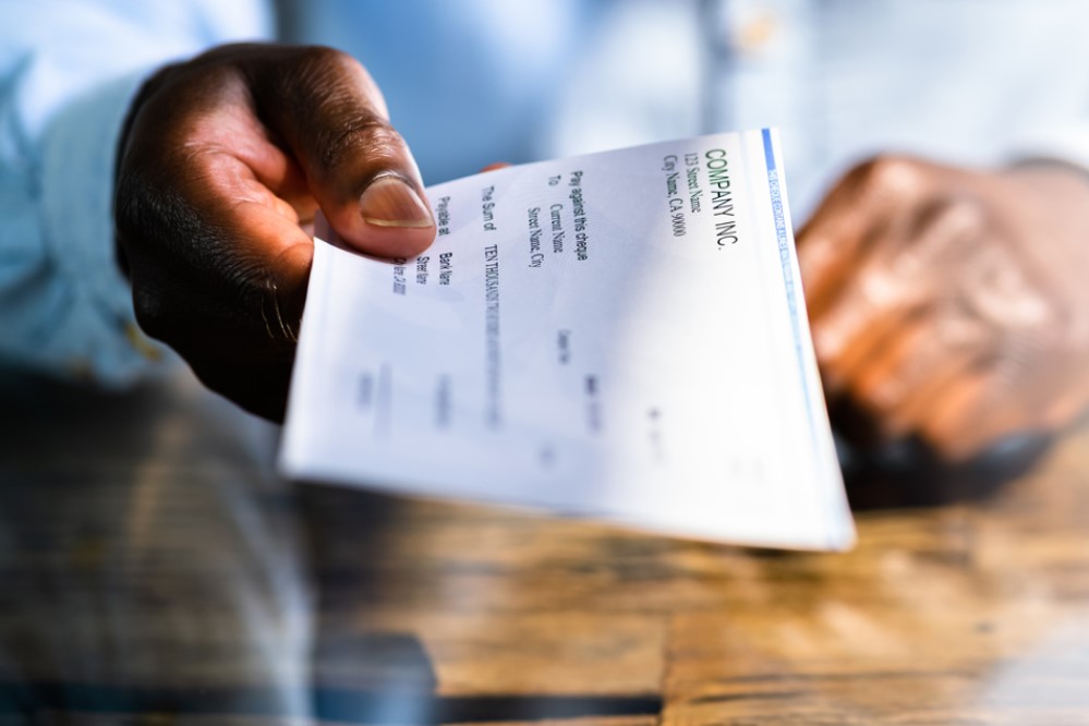 Image of a person handing out a paycheck