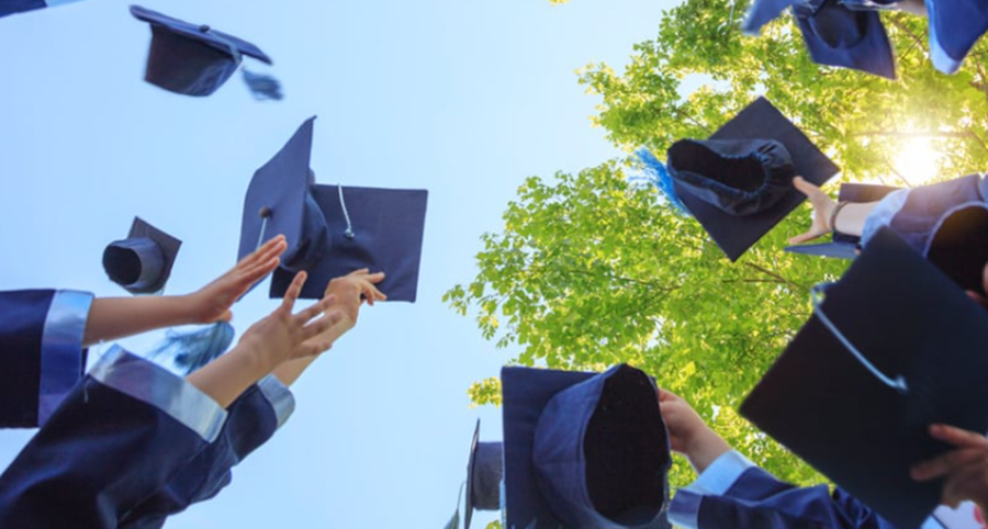 Graduating students throwing caps into the air.