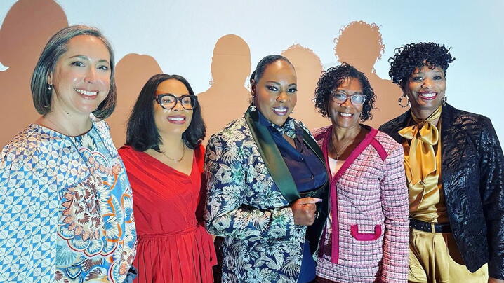 Five strong women, smiling after speaking on a panel