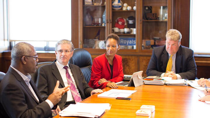 diverse group of businessmen and businesswomen talking around meeting table in a meeting