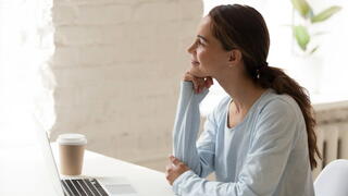 Photo of woman working from home, smiling to herself