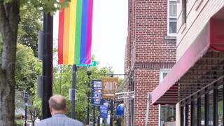 Photo of city street with rainbow Pride flag on display