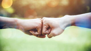 Image of two people bumping fists