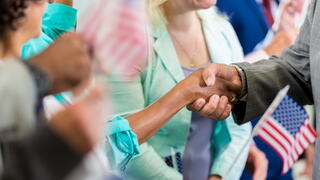 Image of political rally, people shaking hands