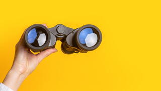 Photo of person holding binoculars