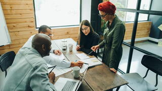 Image of coworkers sitting around a conference table