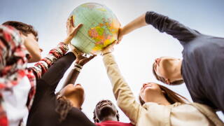 Image of youth holding up a globe